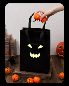 Detalle de bolsa de regalo negra de Halloween con fantasma que brilla en la oscuridad y calabazas