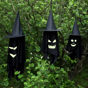 Hanging Halloween witch hat ghost decorations with glowing faces for outdoor tree display