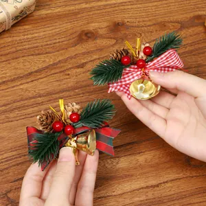 Nœud de décoration de Noël avec aiguilles de pin, baies rouges et cloches dorées