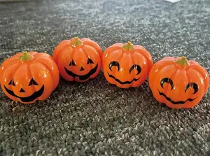 Dettaglio di quattro auto a retrocarica a forma di zucca di Halloween su tappeto.
