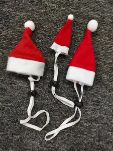 Close-up detail of three miniature red Christmas hats for small pets with elastic straps