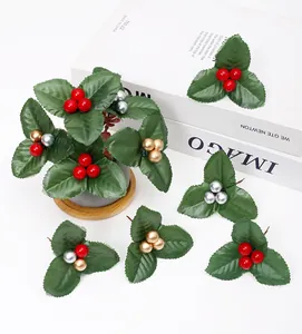 Detailed view of DIY Christmas holly leaf picks with red gold and silver berries
