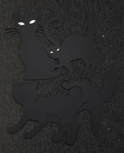 Detailed view of four black cat Halloween yard signs with glowing eyes for garden decor.