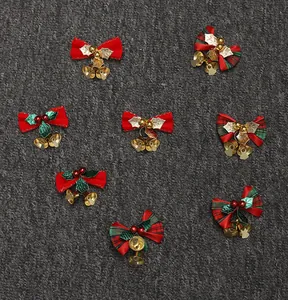 Dettaglio di fiocchi natalizi festivi con campanellini dorati e foglie di agrifoglio