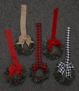 Vijf mini-kerstkransen met diverse linten, waaronder ruitjes- en fluwelen strikken.