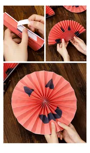 Step-by-step assembly of an orange Halloween paper fan with a demon face design