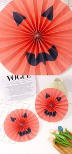 Detailed view of orange Halloween paper fans with pumpkin devil faces for party decoration decor