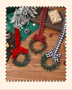 Vue détaillée de mini couronnes de Noël avec nœuds en velours rouge et carreaux sur bois