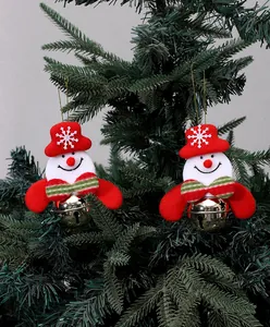 Detailed view of plush snowman ornaments with gold bells hanging on a Christmas tree