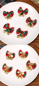 Dettaglio di fiocchi natalizi scozzesi con campanellini dorati per confezioni regalo.
