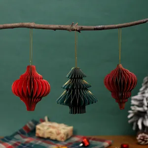 Set di decorazioni natalizie in carta a nido d'ape appese a un ramo su sfondo verde