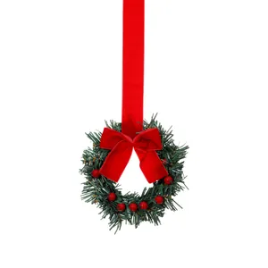Feestelijke kerstkrans voor kastje met rode fluwelen strik en rode bessen decor