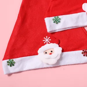 Detailaufnahme einer Weihnachtsmann-Applikation auf einer roten festlichen Mütze