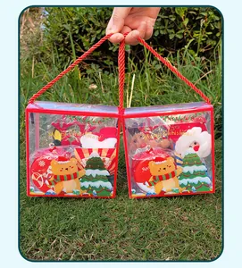 Close-up of Christmas toy gift sets in transparent boxes with red rope handles