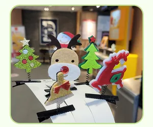 Detailed shot of various Christmas felt hair clips with reindeer, tree, and bell designs.