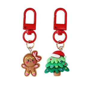 Two Christmas resin keychains featuring a gingerbread man and a festive tree on a white background.