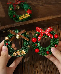 Detailaufnahme von Mini-Weihnachtskranz-Magneten mit roten Beeren und festlichen Schleifen