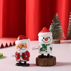 Süßer mechanischer Weihnachtsmann und Schneemann zum Aufziehen vor festlicher Kulisse.