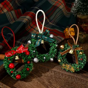 Set of three mini green Christmas wreath hanging ornaments with festive bows and bells