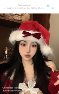 Close-up of a festive red plush Christmas hat with a velvet bow worn by an Asian model