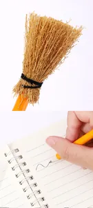 Vista detallada de un lápiz de escoba de bruja miniatura escribiendo en un cuaderno