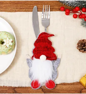 Detalle de porta cubiertos de gnomo rojo para decoración de mesa navideña festiva