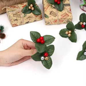 DIY mini Christmas holly leaf pick with shiny red and gold berries for holiday decoration.