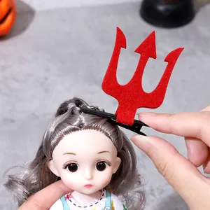 Pince à cheveux trident rouge en feutre pour Halloween présentée sur les cheveux d'une poupée