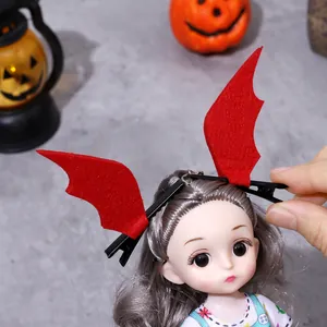 Vibrant red Halloween bat wing hair clips presented on a doll head for party decor.