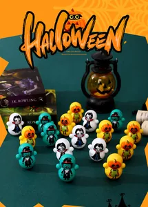 Mini Halloween pumpkin and vampire tumbler toys arranged on a dark green desk