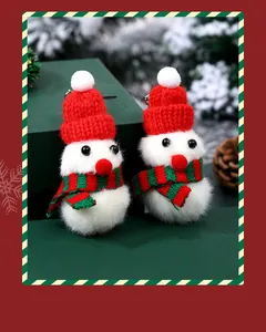 Nahaufnahme von zwei Mini-Plüsch-Schneemännern mit roten Strickmützen und Schals