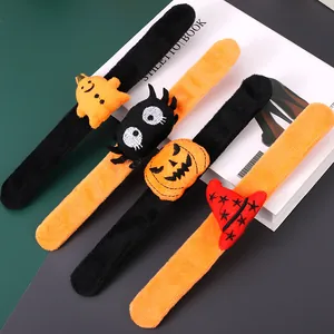 Detail view of four Halloween plush slap bracelets with pumpkin, spider, and ghost.
