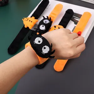 Close-up of a spider plush slap bracelet worn on a wrist for Halloween decoration