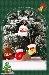 Primer plano de lindos adornos navideños de peluche como renos y muñecos de nieve en un árbol