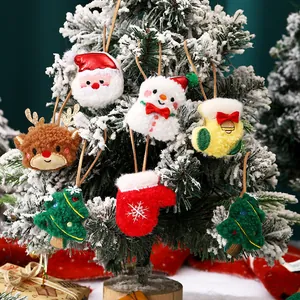 Adorables adornos navideños de felpa con Papá Noel, reno y muñeco de nieve en un árbol.