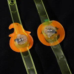 Zwei Halloween-Leuchtarmbänder mit Kürbismotiven und sichtbaren Batteriefächern