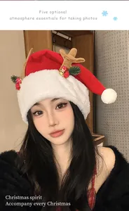 Detailed view of model wearing plush red Christmas hat with reindeer antler decorations