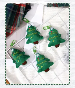 Vista dettagliata di portachiavi a forma di albero di Natale in peluche con ricamo festivo.