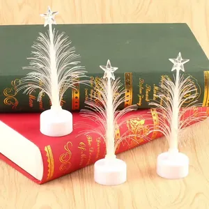 Árboles de Navidad de fibra óptica LED que cambian de color sobre libros