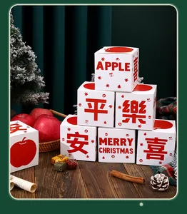 Set di scatole regalo natalizie per mele con stampe rosse su tavolo in legno