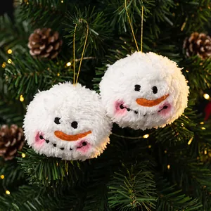 Deux adorables boules de bonhomme de neige en peluche suspendues à un sapin de Noël festif.