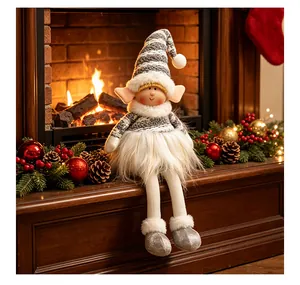 Muñeco de peluche elfo de Navidad hecho a mano con gorro de rayas en una chimenea festiva