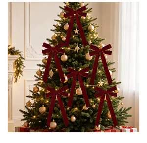 Elegant burgundy velvet bows decorating a lit Christmas tree with golden ornaments