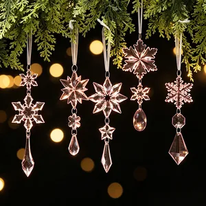Elegante acryl sneeuwvlok en ijspegel kerstversiering hangend aan dennentakken.