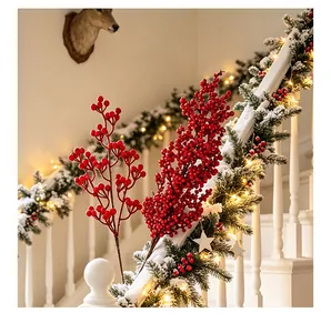 Primo piano di rami di bacche rosse artificiali su una ghirlanda festiva di Natale