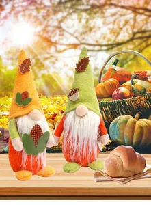 Dettaglio di due gnomi della festa del raccolto decorati con foglie autunnali e mais