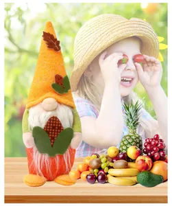 Gnomo di peluche per la festa del raccolto con decorazione di mais e frutta fresca