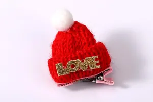 Makroansicht der roten gestrickten Weihnachtsmütze-Haarspange mit goldenem LOVE-Glitzer