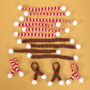 Detailweergave van mini gebreide kerstsjaals met rode, groene en witte strepen