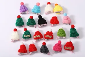 Detail von bunten Mini-Strickmützen-Haarspangen mit Pompons und LOVE-Schriftzug